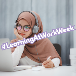 Photo of a hijabi lady sat at her laptop with pen in hand. The phrase #LearningAtWorkWeek is overlaid
